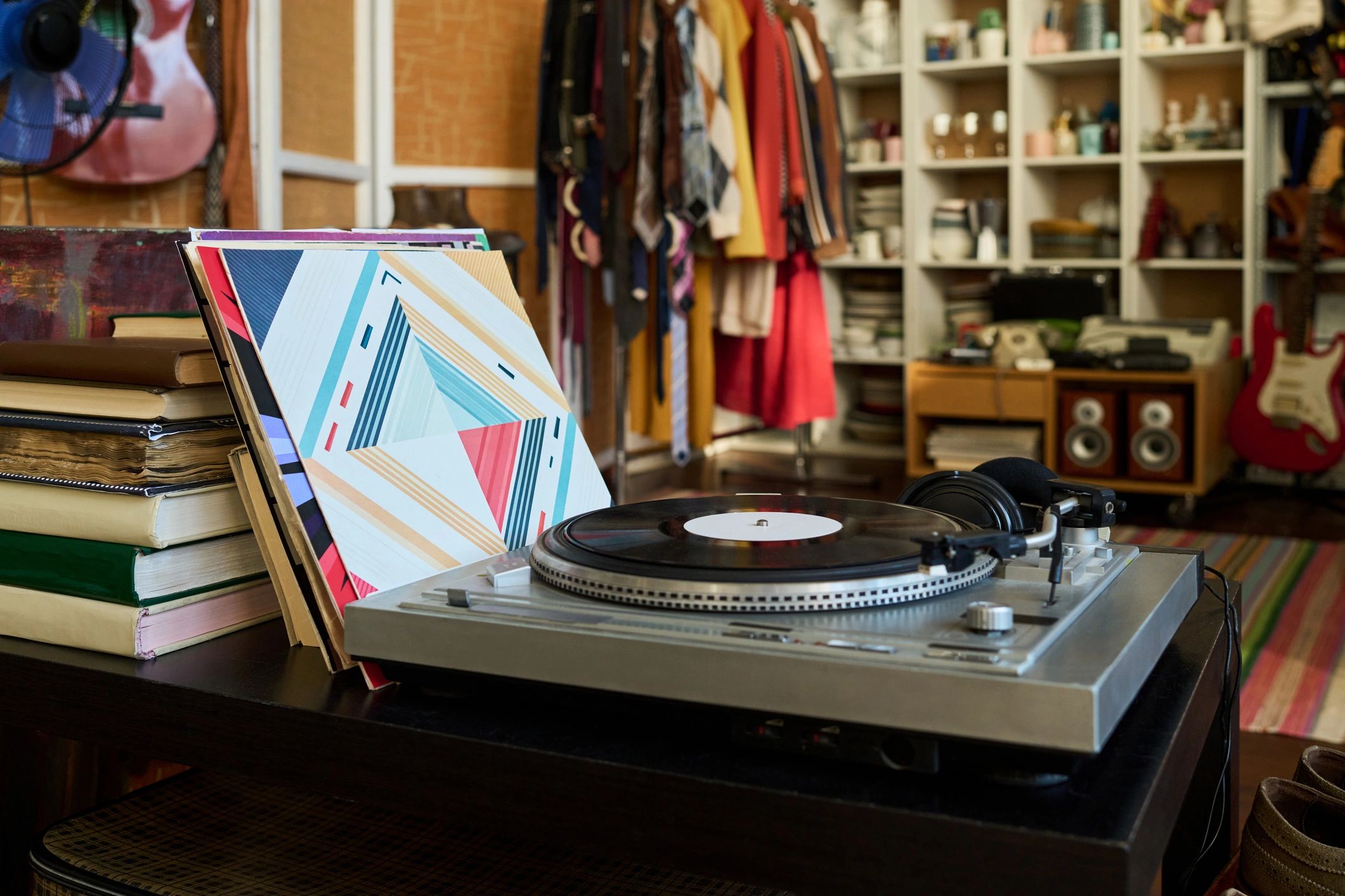 Vintage turntable playing a vinyl record with album covers nearby