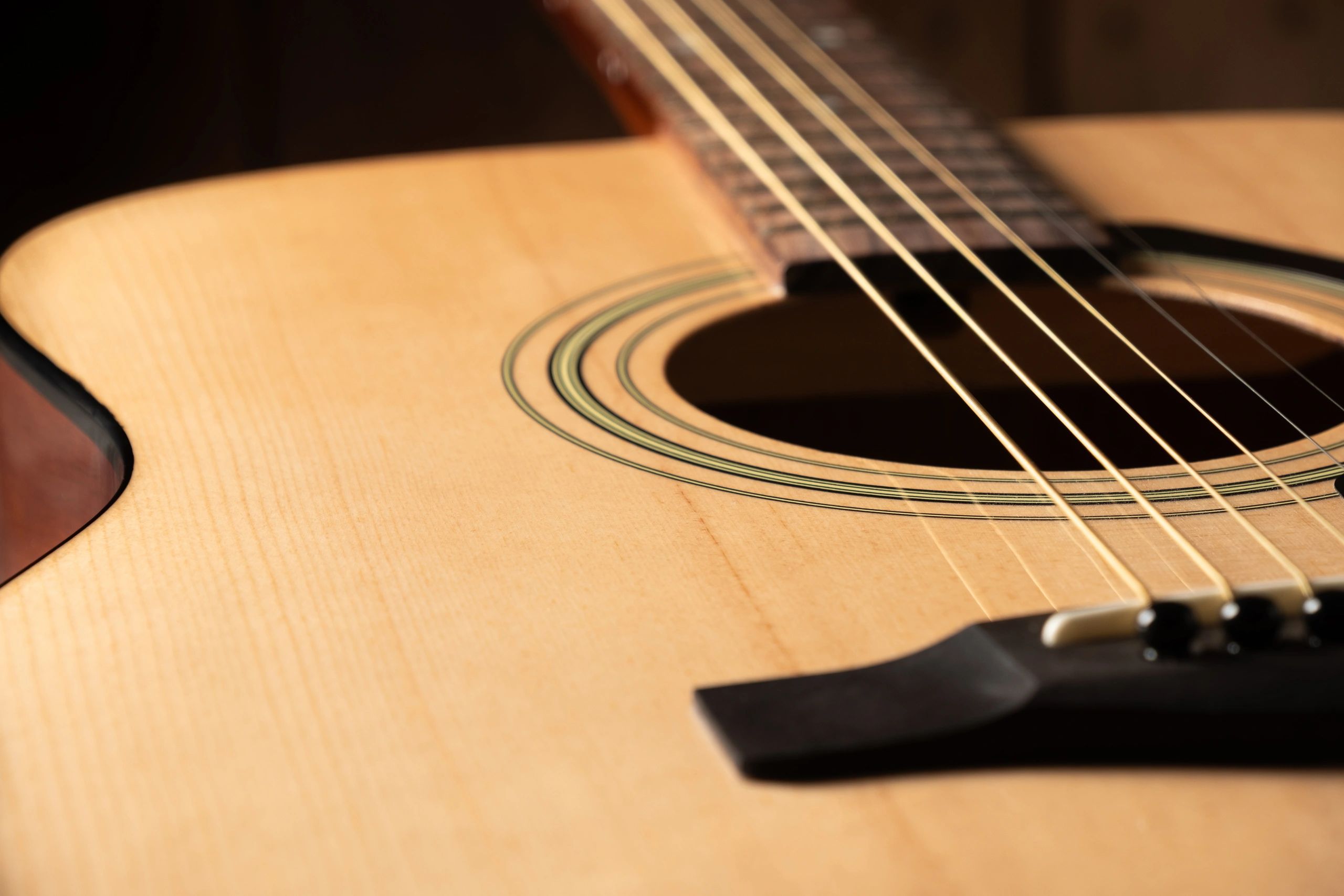 Close-up of an acoustic guitar under warm studio lighting